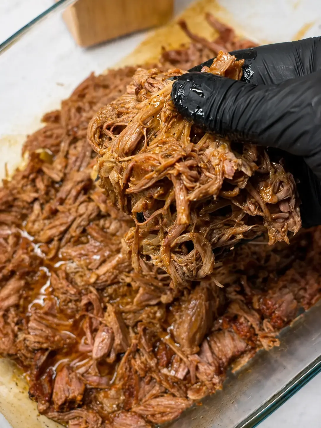 Szarpana wieprzowina pulled pork z karkówki na desce do krojenia, podana w bułce burgerowej z surówką colesław