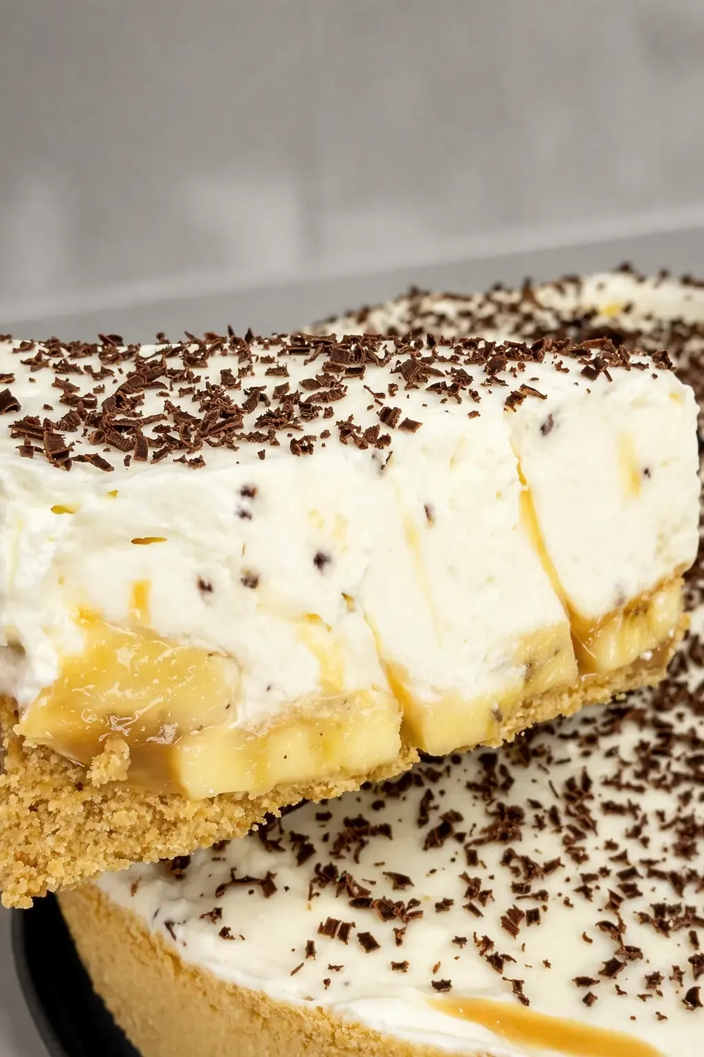 Ciasto banoffee przekrojone na porcje, z warstwą kajmaku, bananów i kremu mascarpone