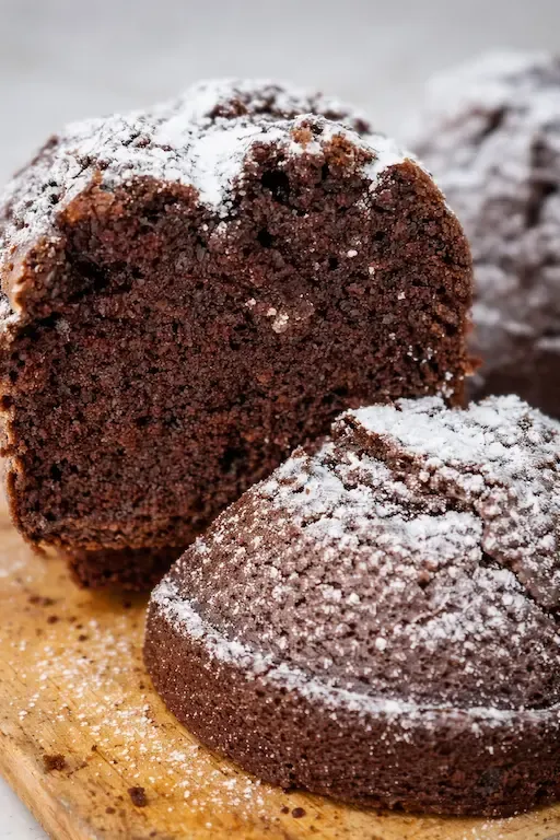 Wilgotna babka czekoladowa pokrojona w plastry, posypana cukrem pudrem