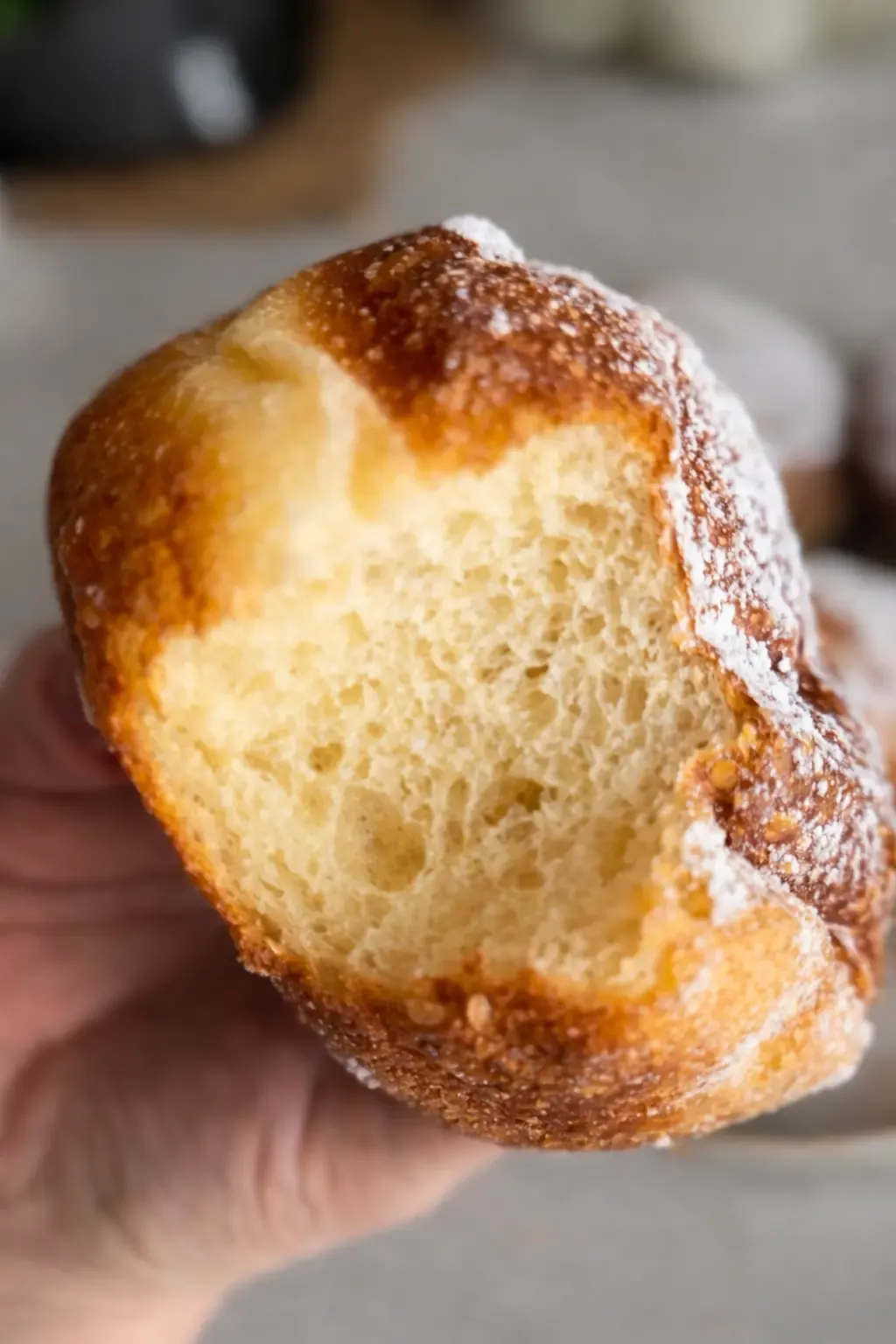 Domowe pączki posypane cukrem pudrem zdjecie ugryzionego puszystego paczka