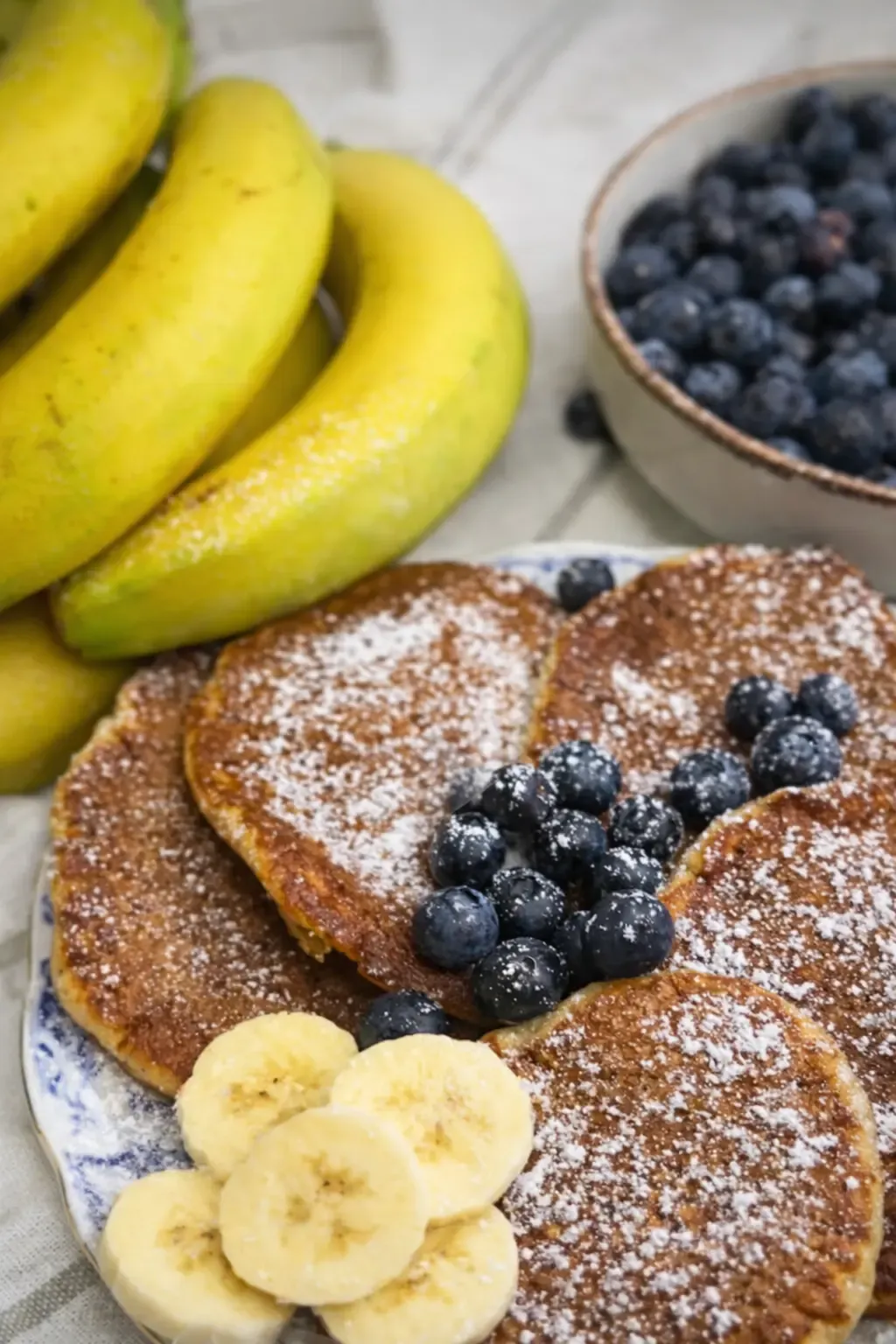 Stos pancake'ów bananowych ze skyrem, polanych syropem i udekorowanych owocami 
